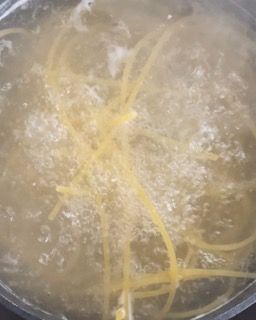 Gli spaghetti vengono cotti in una pentola d'acqua.