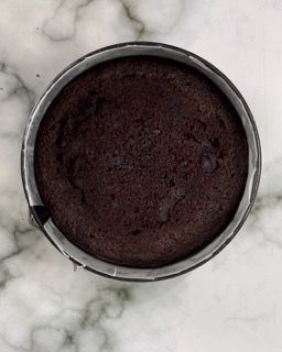 Una torta al cioccolato in una teglia su una superficie di marmo.