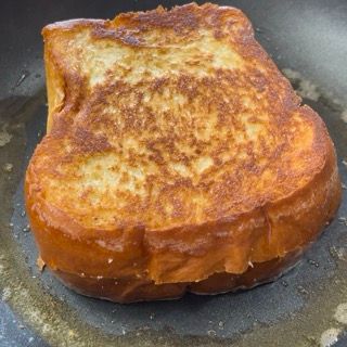 Un pezzo di pane tostato francese viene cotto in una padella