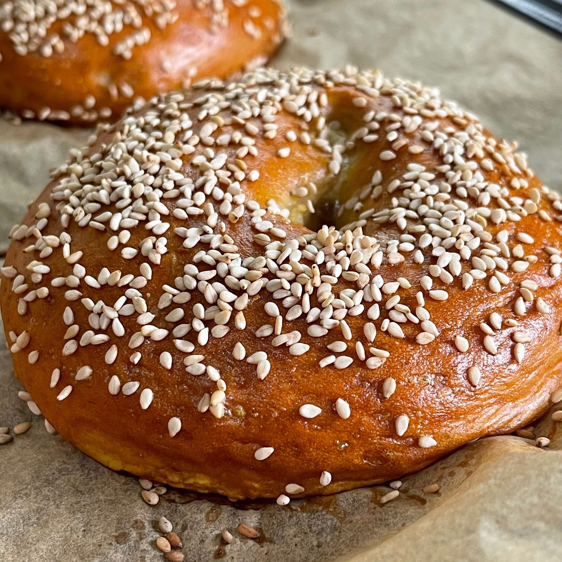Un bagel con semi di sesamo è appoggiato su un tavolo.