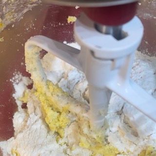 Un mixer mescola farina e burro in una ciotola.