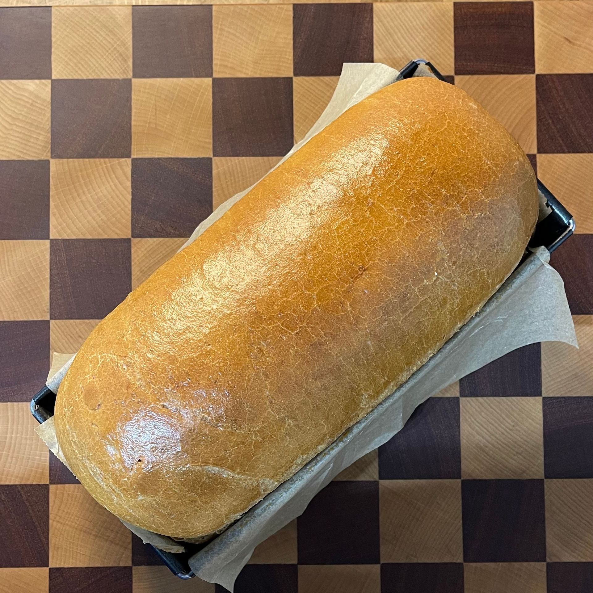 Una pagnotta di pane è appoggiata su un tavolo a scacchi