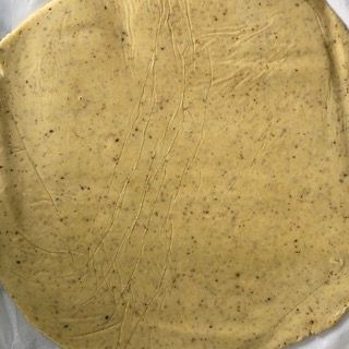 Primo piano dell'impasto della pizza su un tavolo.