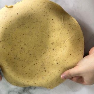 Una persona tiene in mano un pezzo di pasta.