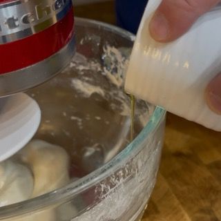 Una persona sta versando qualcosa in un mixer KitchenAid