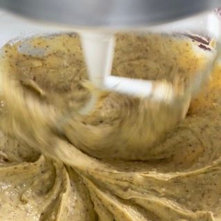 Primo piano di un mixer che mescola un impasto in una ciotola.