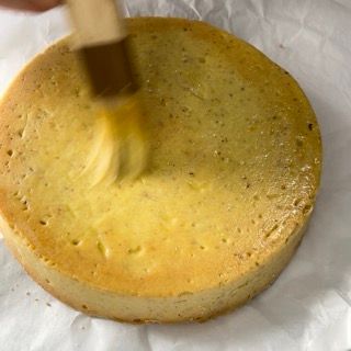 Una persona sta spalmando il burro su una cheesecake con un pennello