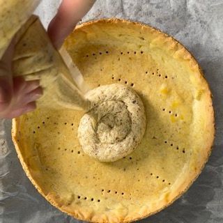 Una persona sta versando del liquido in una crosta di torta