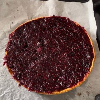 Una torta con un sacco di salsa di frutti di bosco sopra