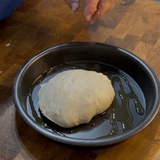Una padella nera con dentro un pezzo di pasta
