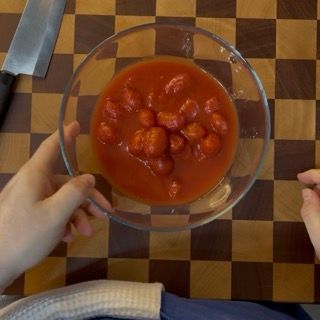 Una persona tiene in mano una ciotola di salsa di pomodoro