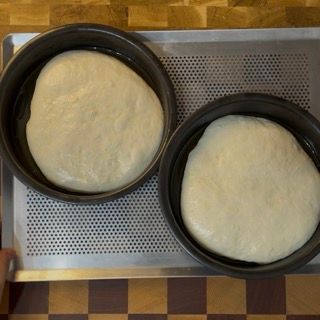 Due teglie di pasta sono appoggiate su una teglia forata