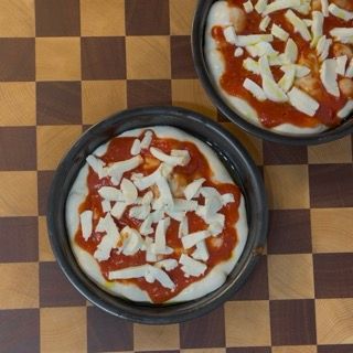 Due pizze sono appoggiate su un tavolo a scacchi