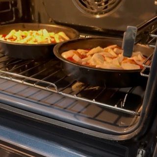 Due teglie di cibo stanno cuocendo in un forno