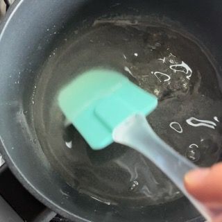 Una persona tiene una spatola sopra una pentola d'acqua