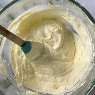 Una ciotola di glassa con un cucchiaio di legno dentro