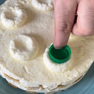 Una persona sta mettendo un berretto verde su una torta