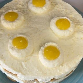Una torta bianca con uova gialle sopra su un piatto blu
