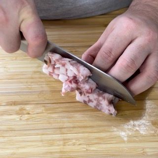 Una persona sta tagliando un pezzo di carne su un tagliere