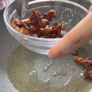 Una persona sta versando la pancetta in una ciotola di olio