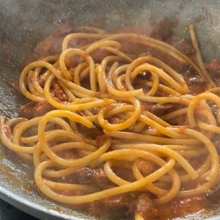 Gli spaghetti vengono cotti in padella con sugo di pomodoro