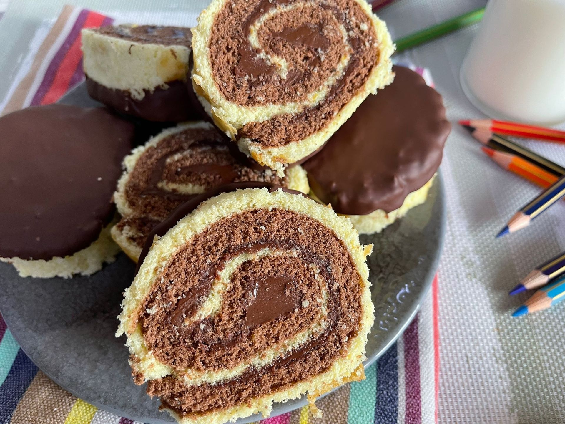 Un piatto di panini al cioccolato su un tavolo con delle matite.