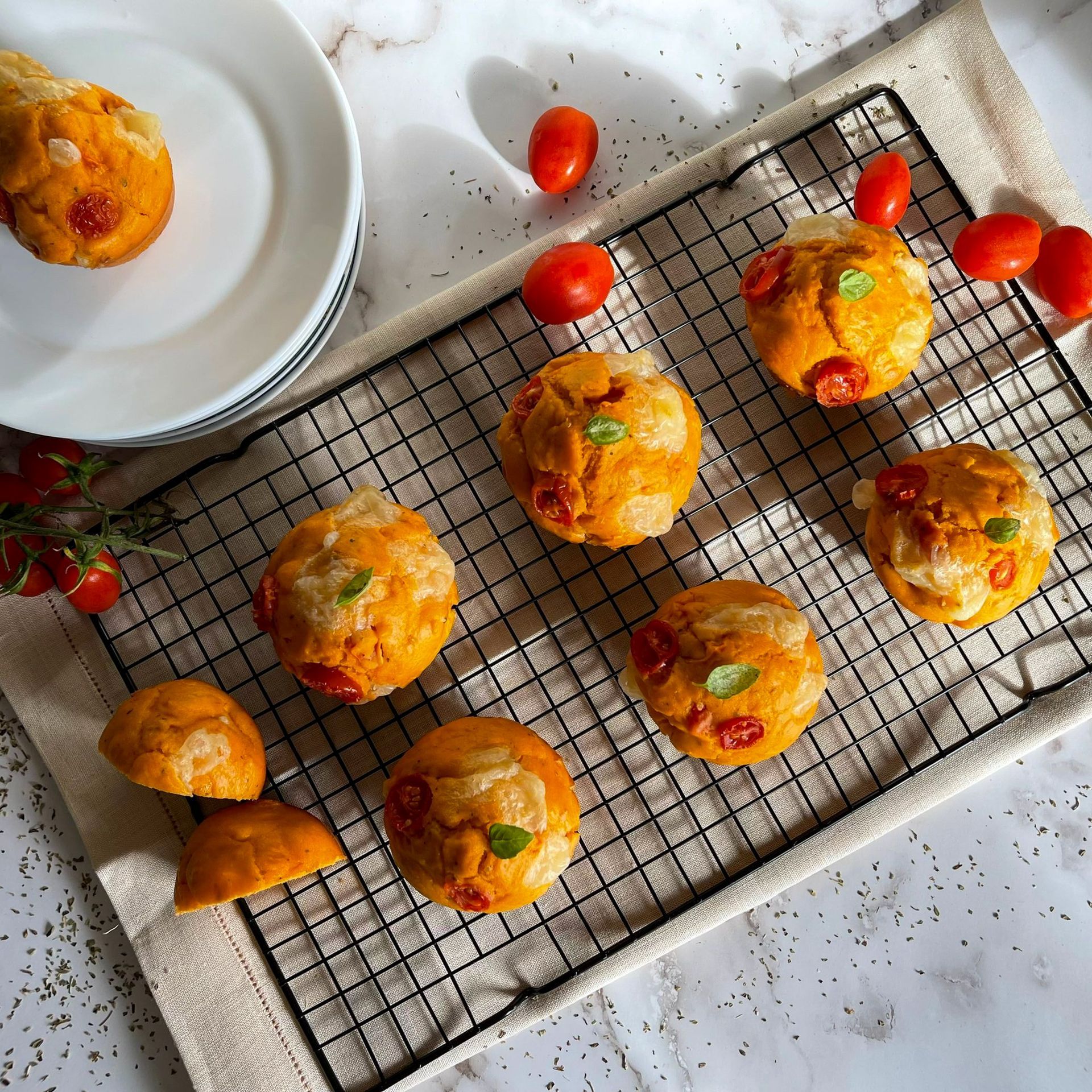 Un mucchio di muffin appoggiati su una griglia di raffreddamento.