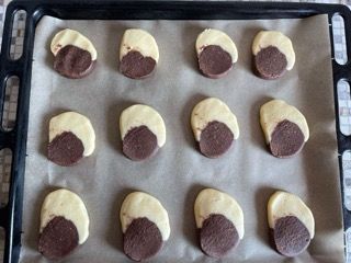 Un vassoio di biscotti bianchi e neri su carta oleata