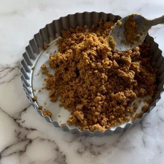 Una padella di metallo piena di polvere marrone con un cucchiaio dentro