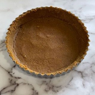 Una crosta di torta è appoggiata su una superficie di marmo.