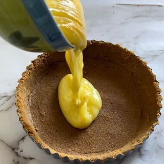 Il liquido giallo viene versato in una crosta di torta