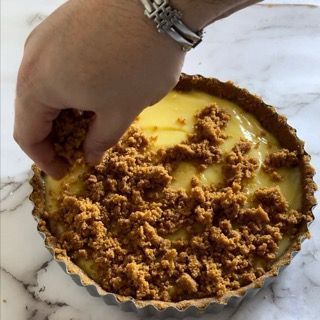 Una persona che indossa un orologio sta mettendo le briciole su una torta