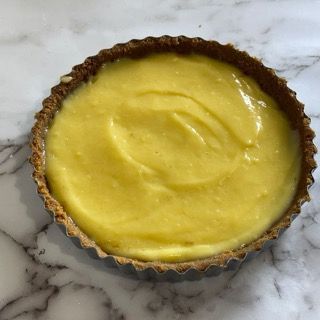 Una crostata con una crosta marrone farcita con crema gialla