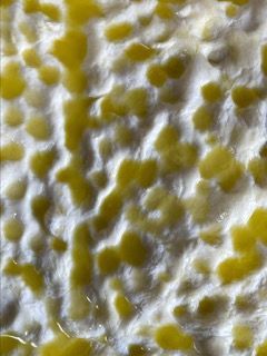 Un primo piano di una superficie bianca con macchie gialle su di essa