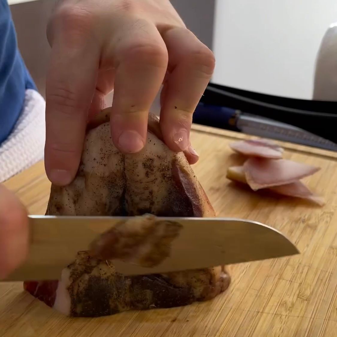 Una persona sta tagliando un pezzo di carne su un tagliere