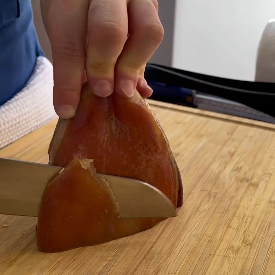 Una persona sta tagliando un pezzo di carne su un tagliere.