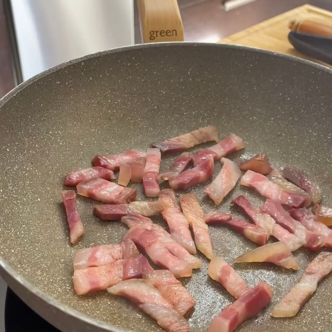 La pancetta viene cotta in una padella con il manico verde