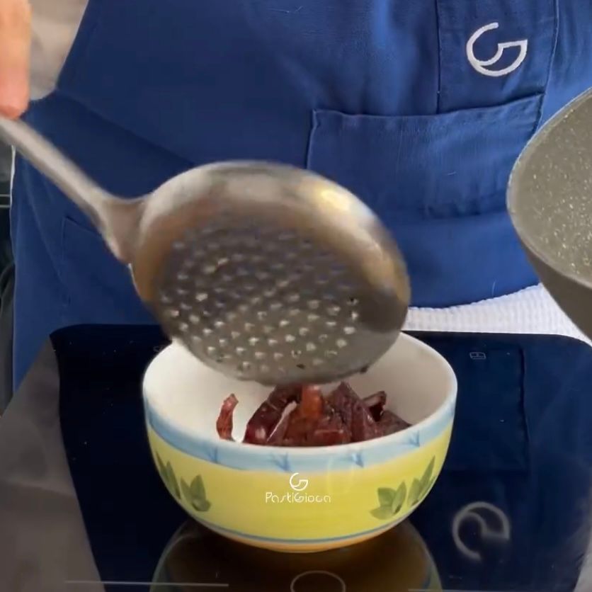 Una persona con un grembiule blu sta versando qualcosa in una ciotola