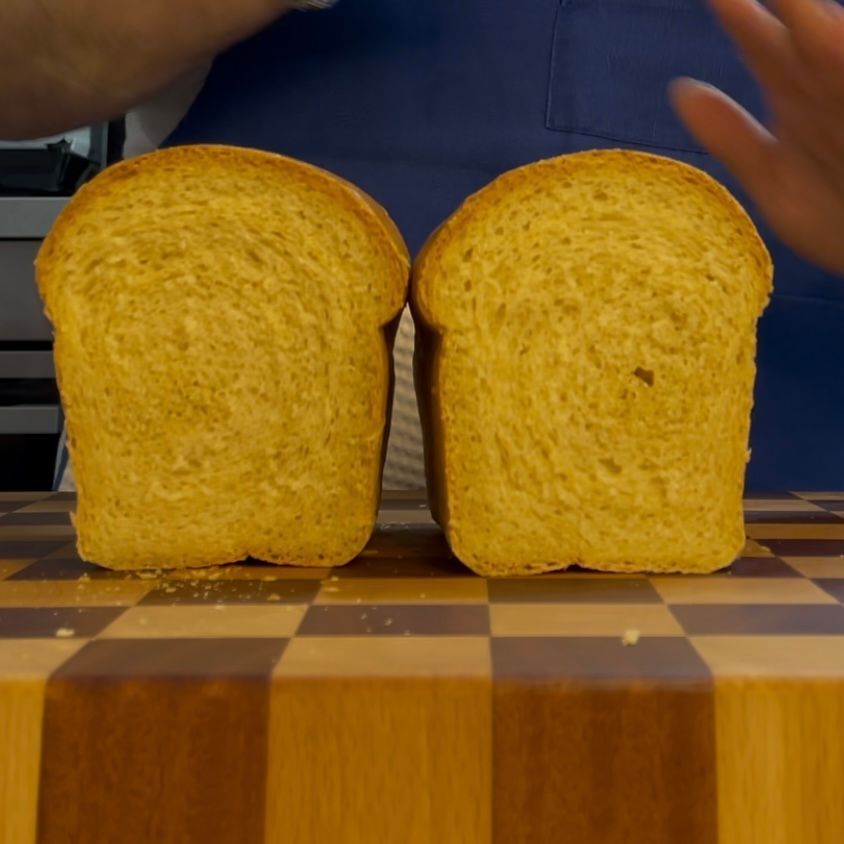 Due fette di pane sono appoggiate su un tagliere di legno