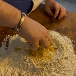 Una persona sta mescolando gli ingredienti in un mucchio di farina