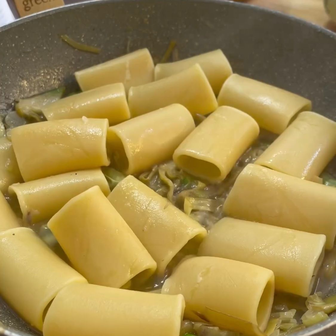 Un primo piano di una padella piena di pasta e verdure