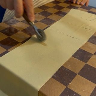 Una persona sta usando un mattarello su un pezzo di carta