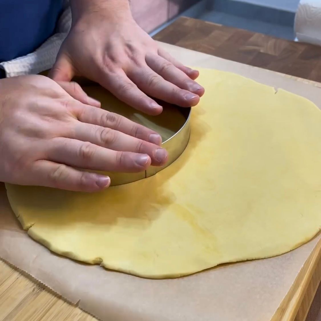 Una persona sta ritagliando un cerchio da un pezzo di pasta.