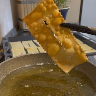 Un pezzo di cibo viene immerso in una pentola di liquido