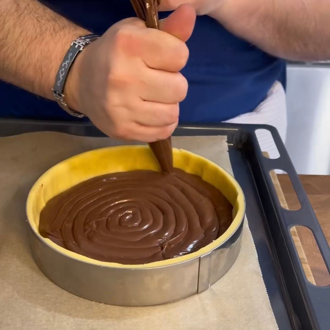 Una persona sta versando il cioccolato nella crosta di una torta