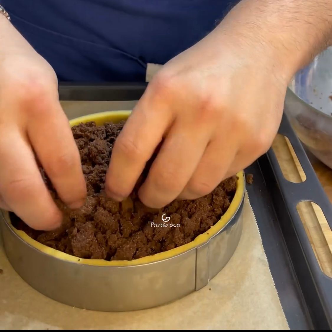 Una persona sta preparando una torta al cioccolato in una teglia di metallo