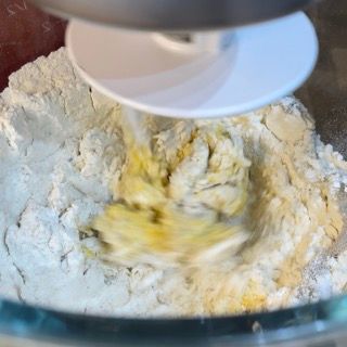 Un mixer sta mescolando la farina e il burro in una ciotola di vetro