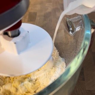 Il latte viene versato in una ciotola di vetro con la farina