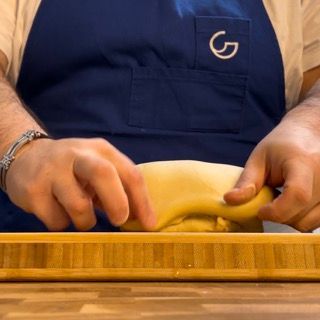 Una persona che indossa un grembiule con la scritta ag sopra