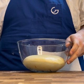 Una persona che indossa un grembiule con la lettera g sopra